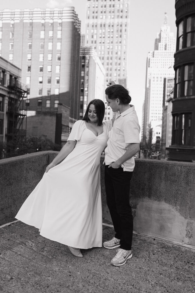 Black and white photo of a couple posing on a Detroit rooftop. 