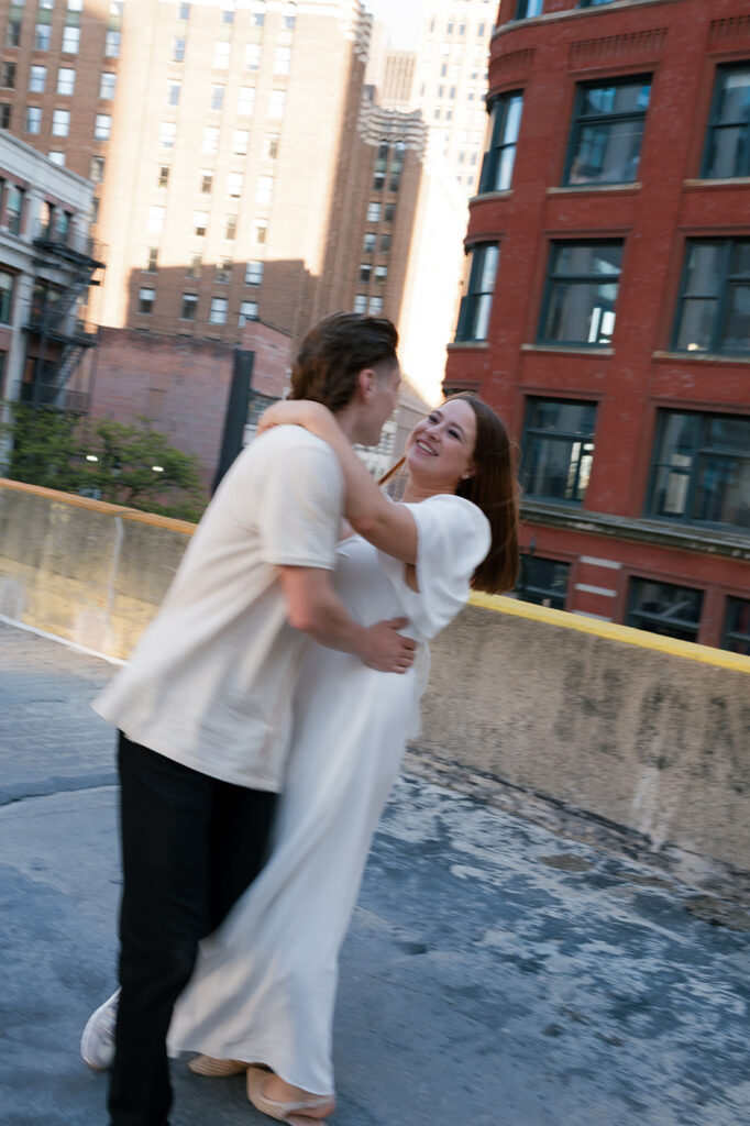 Couple moving and being playful on a rooftop. 