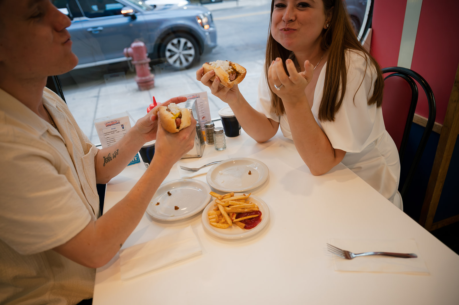 Candid photo of a couple eating Coney Dogs together in Detroit at American Coney Island.