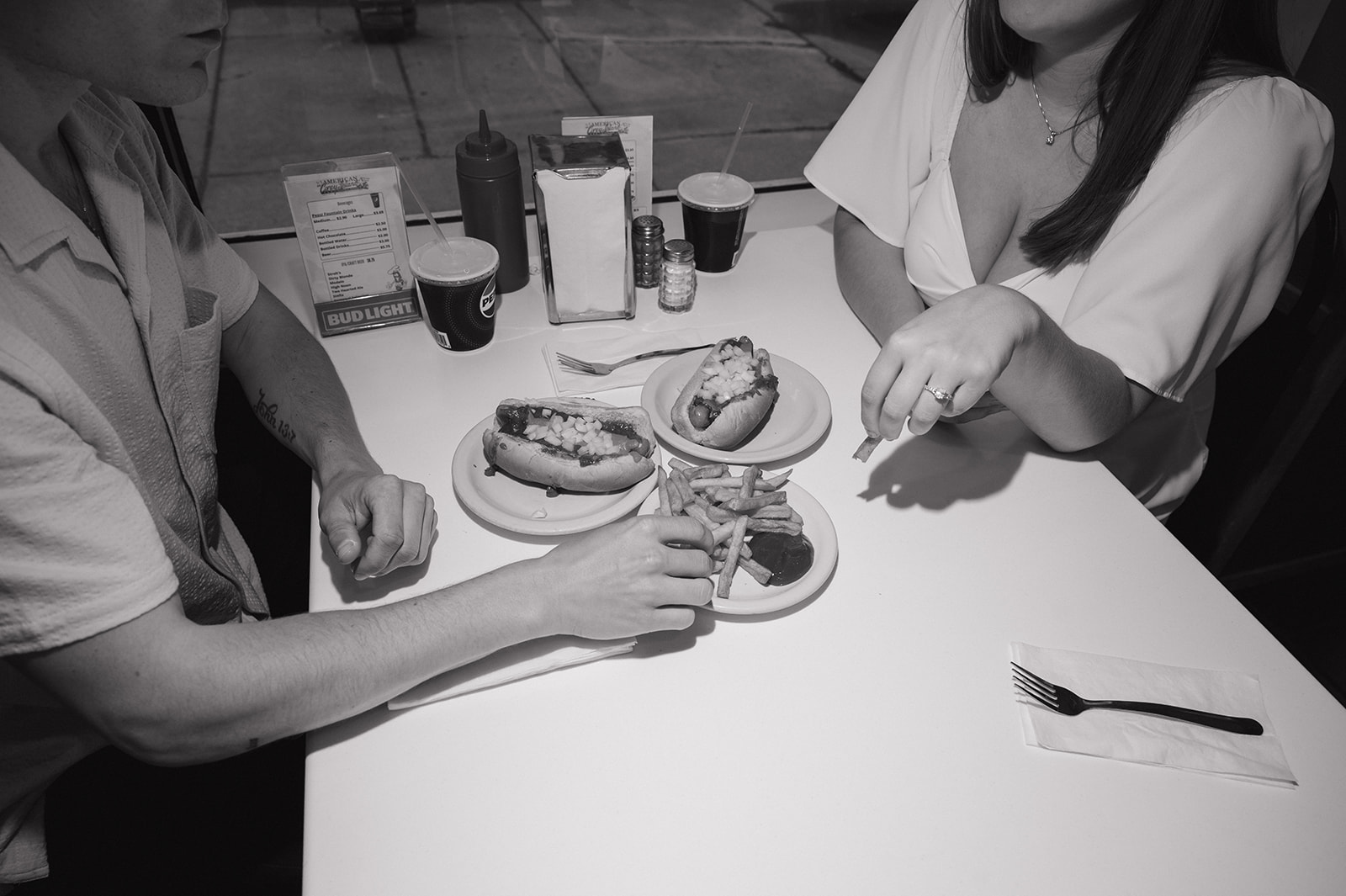 Black and white flash photo of a couple eating coney dogs and fries in Detroit. 