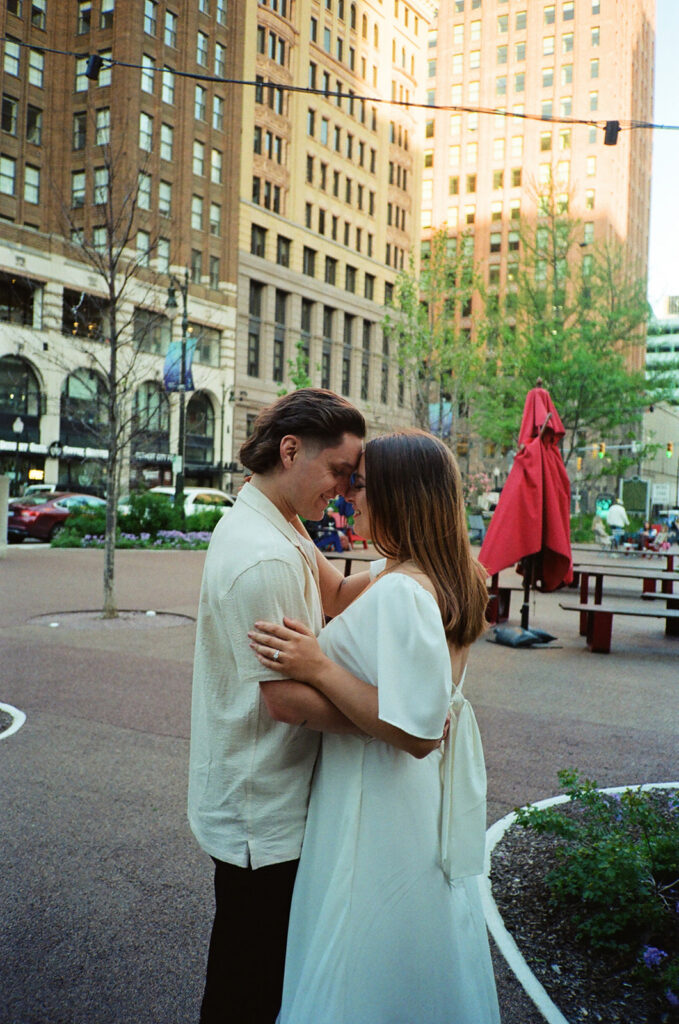 35mm film photo of a couple posing close together downtown.