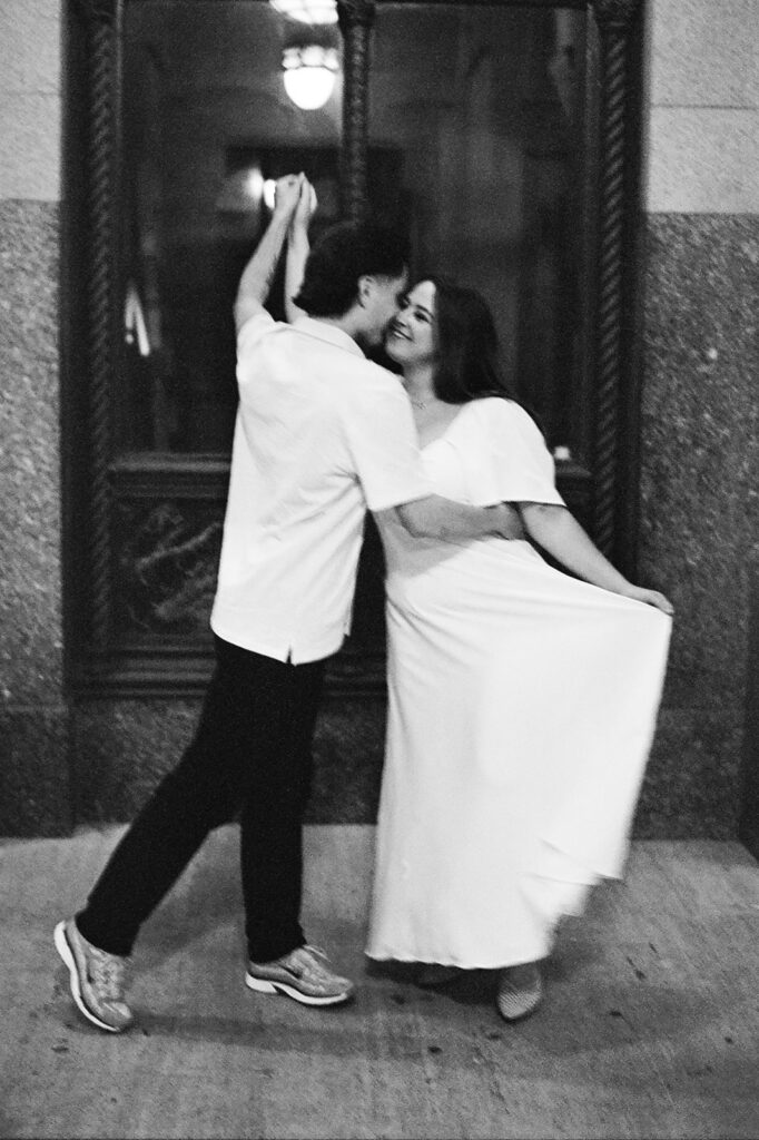 35mm film photo of a couple dancing on a sidewalk in downtown Detroit. 