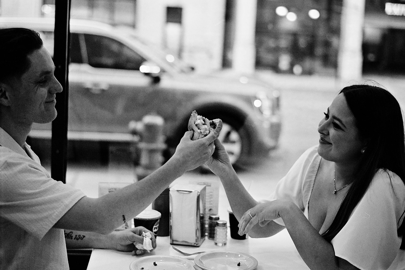 Black and white photo of a couple eating coney dogs at American Coney Dog in Detroit.