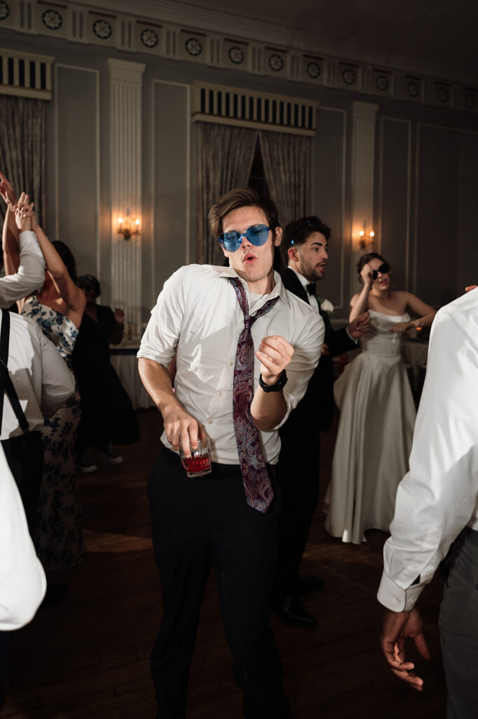 Flash photo of guests dancing during a Metro Detroit wedding reception at Meeting House Grand Ballroom in Plymouth.