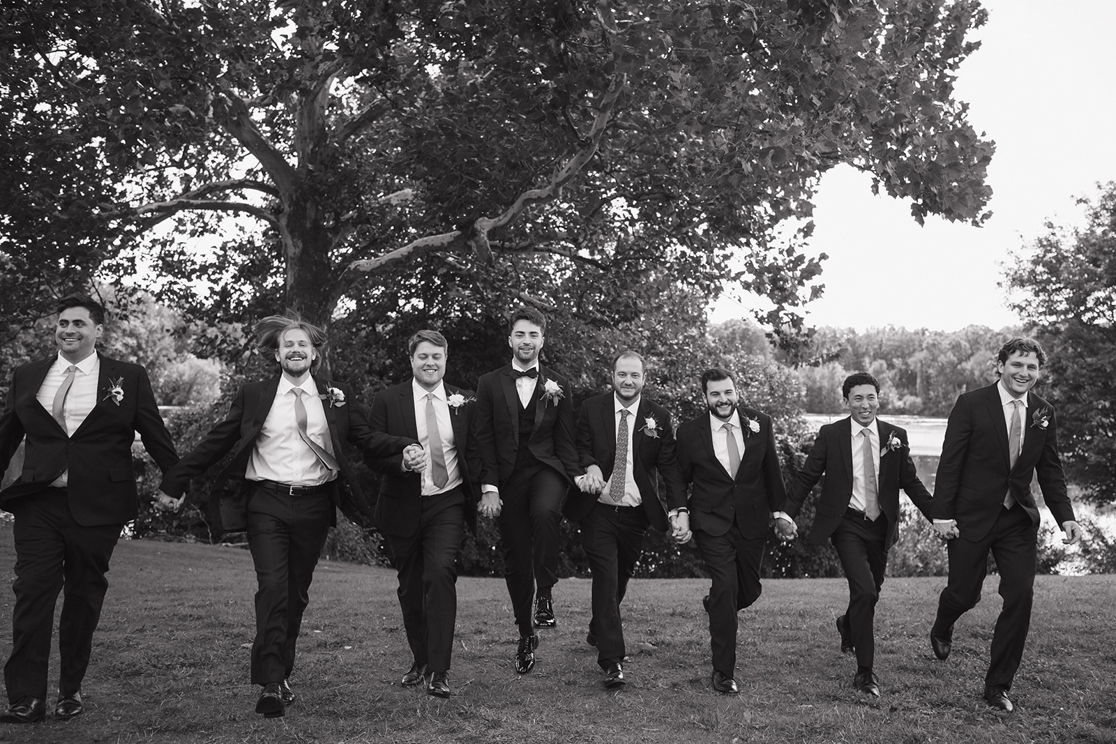 Groom and groomsmen posing in front of a pond at Kellogg Park in Plymouth.