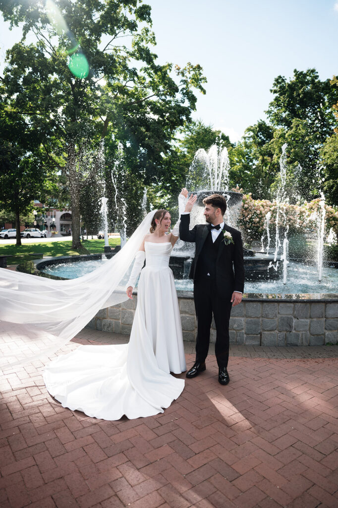 Bride and groom posing in front of the water fountain at Kellogg Park in Plymouth, Michigan.