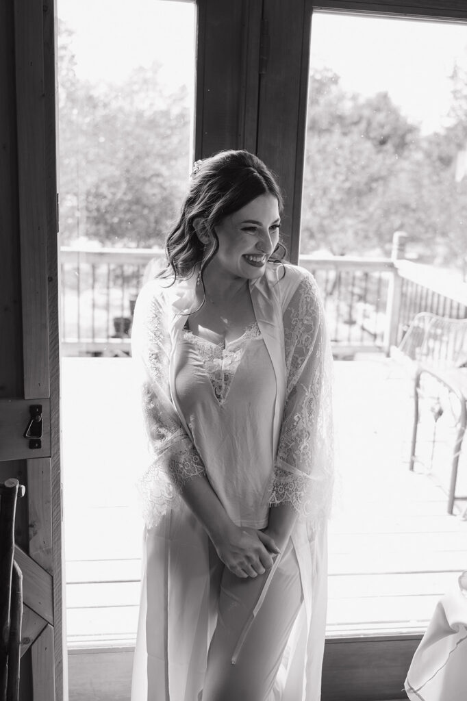 Black and white portrait of a bride in her robe as she gets ready for her wedding.