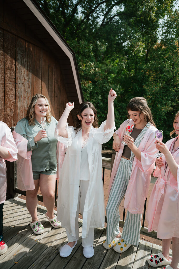 Bride and bridesmaids celebrating in their pajamas as they get ready for a wedding day in Owosso, Michigan.