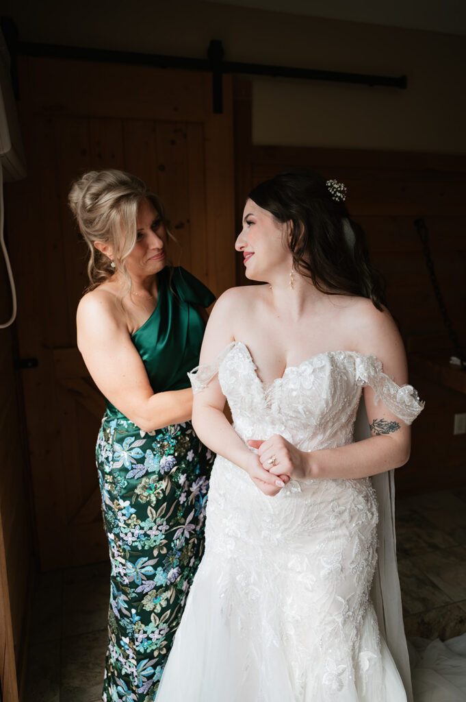 Brides mother helping her into her dress for her Owosso, Michigan wedding.