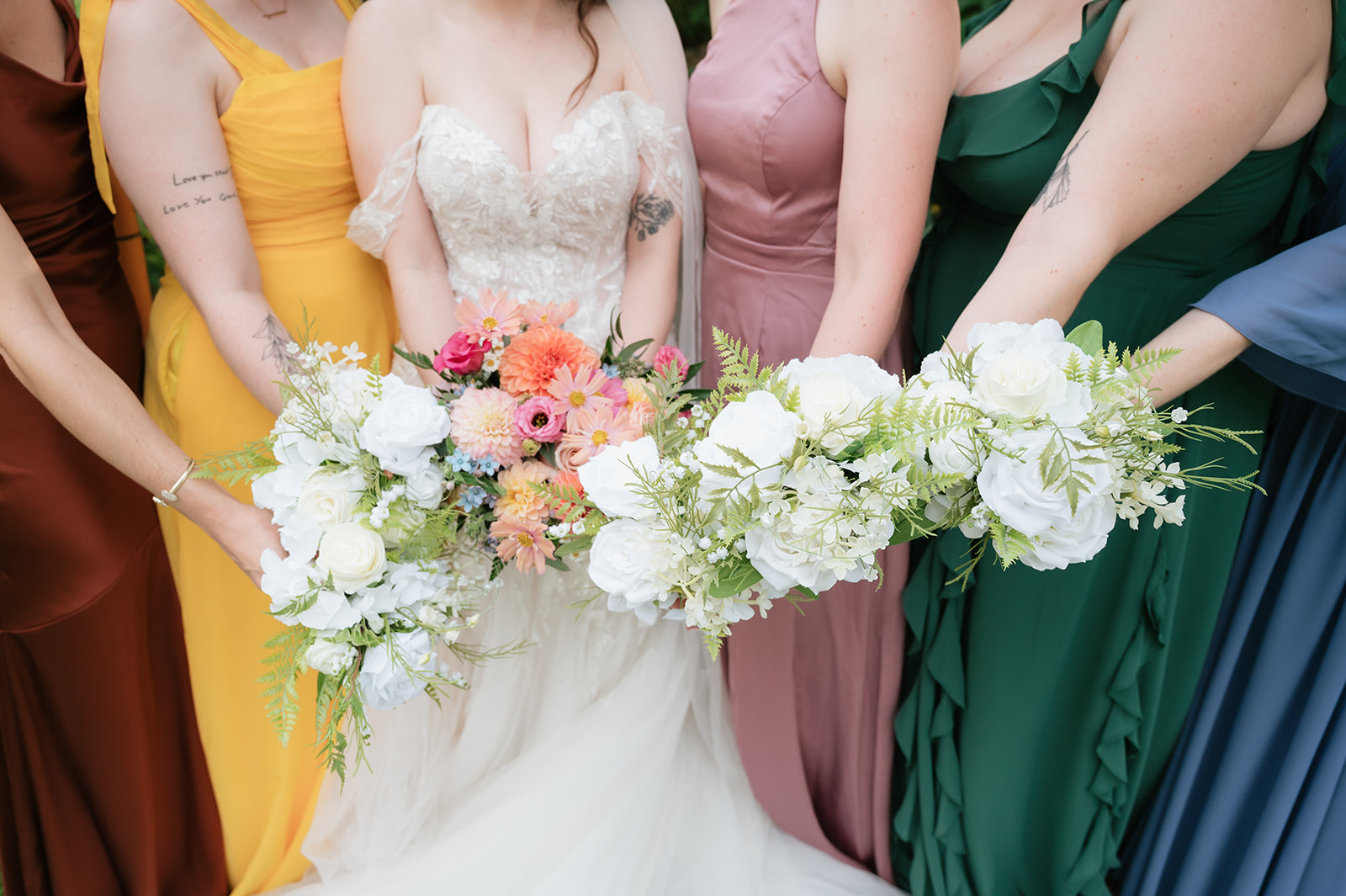 Close up photo of a bride and bridesmaids holding bouquets during an Everlastings in the Wildwood wedding.