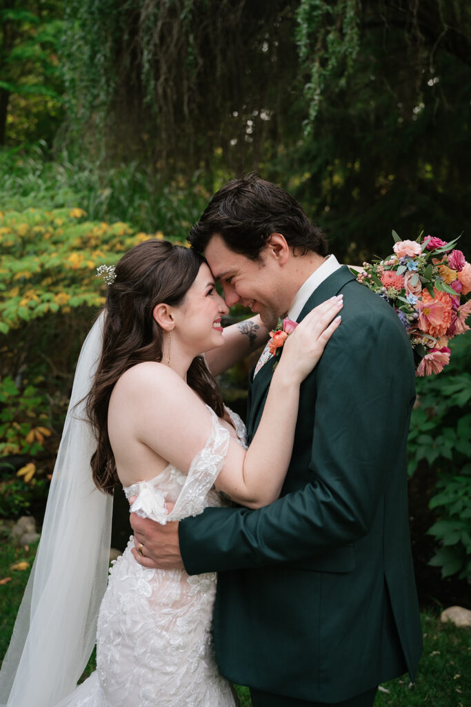 Bride and groom smiling at each other during their Everlastings in the Wildwood wedding photos. 