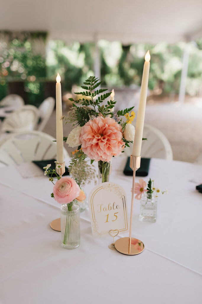 Table 15 with floral centerpieces and candles from a Everlastings in the Wildwood wedding reception.