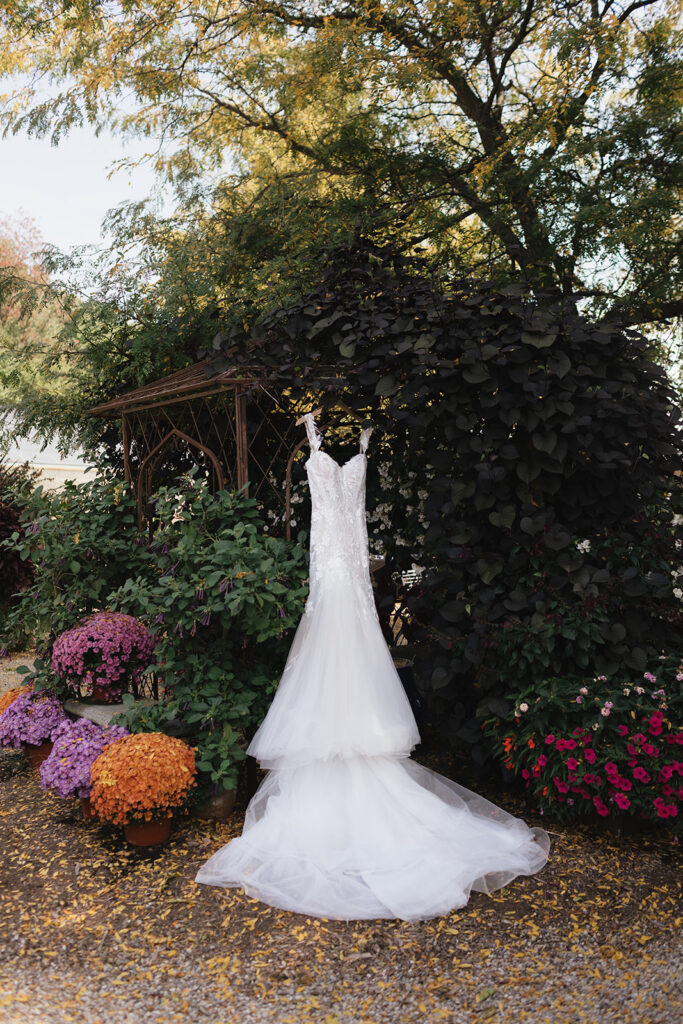Brides dress hanging in the garden area for detail photos.