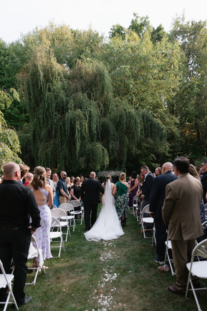 Bride walking down the aisle with her parents during an Owosso, Michigan wedding.