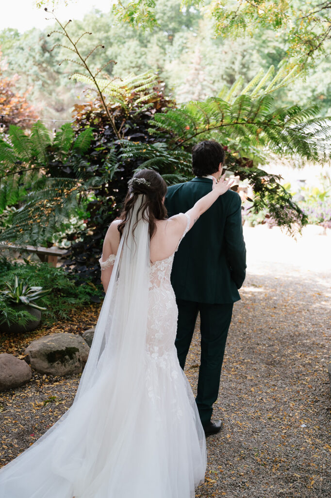 Bride tapping the groom on the shoulder during their garden first look at Everlastings in the Wildwood.