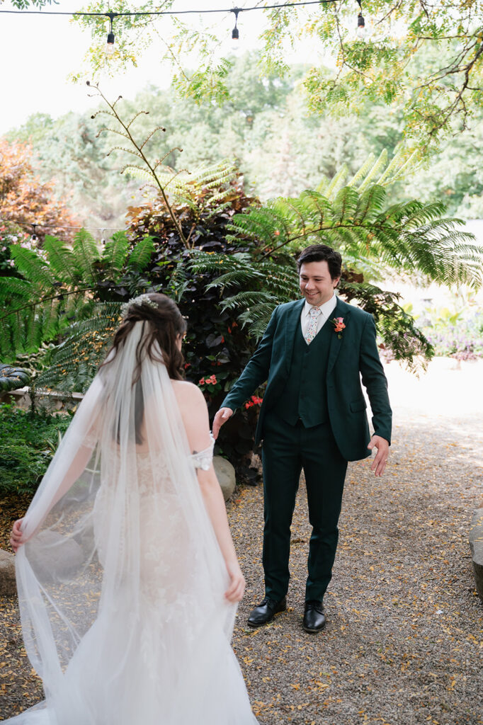 Bride and groom seeing each other during their garden first look at Everlastings in the Wildwood.