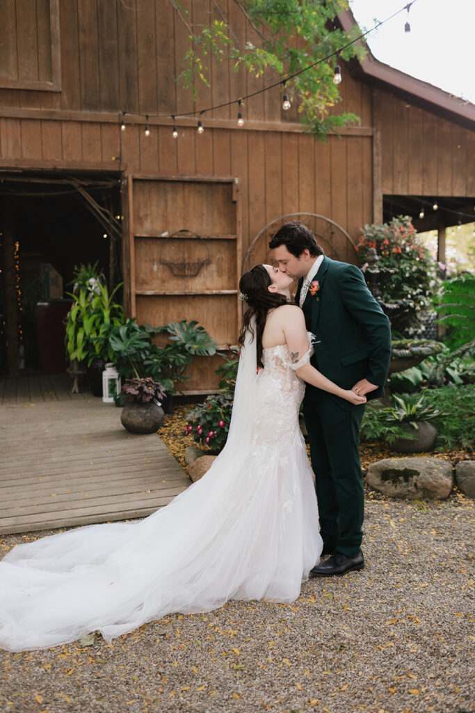Bride and groom kissing after during their garden first look at Everlastings in the Wildwood.