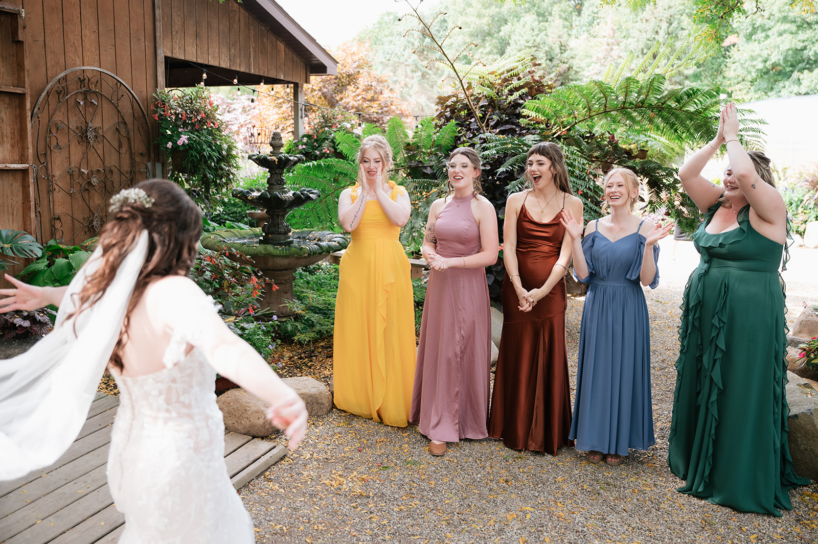 Bride sharing a first look with her bridesmaids in the gardens at Everlastings in the Wildwood.