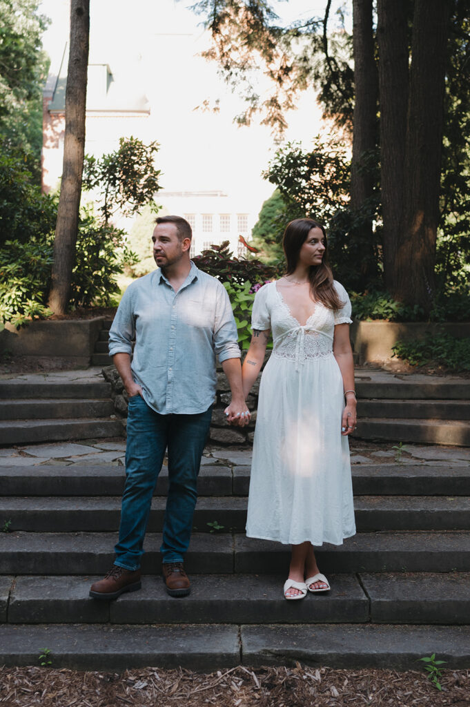 Couple holding hands on stone garden steps at Aquinas College.