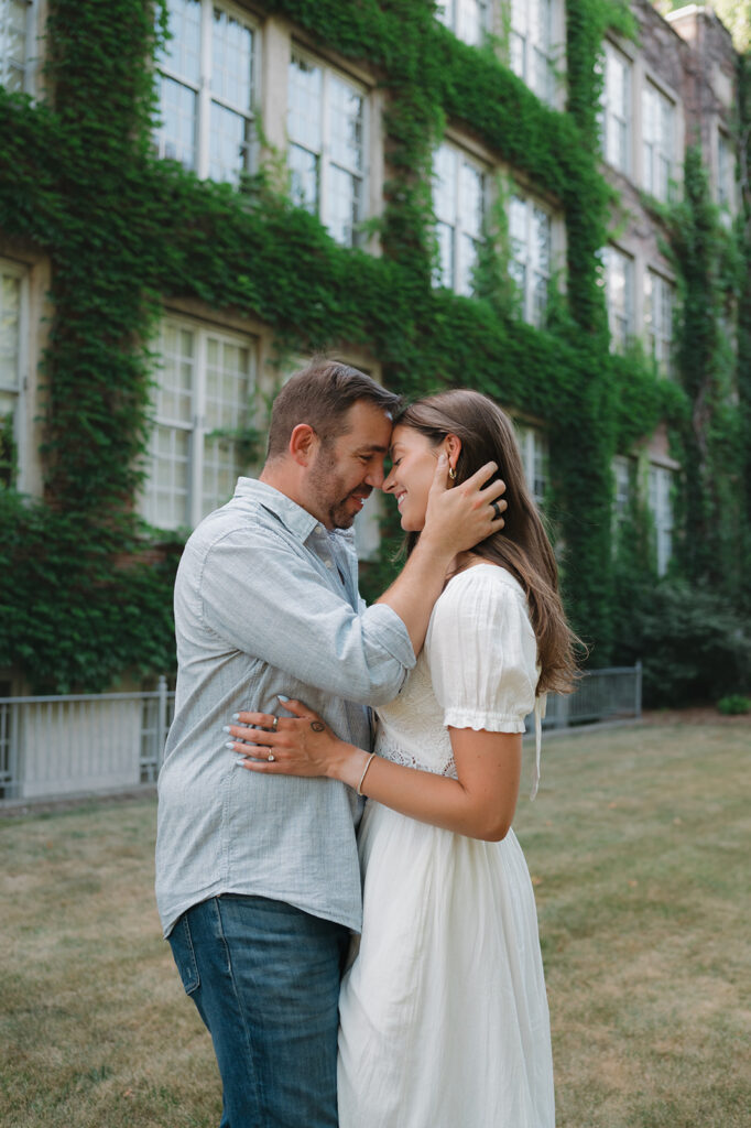 Couple laughing together on a lawn surrounded by trees in Grand Rapids.