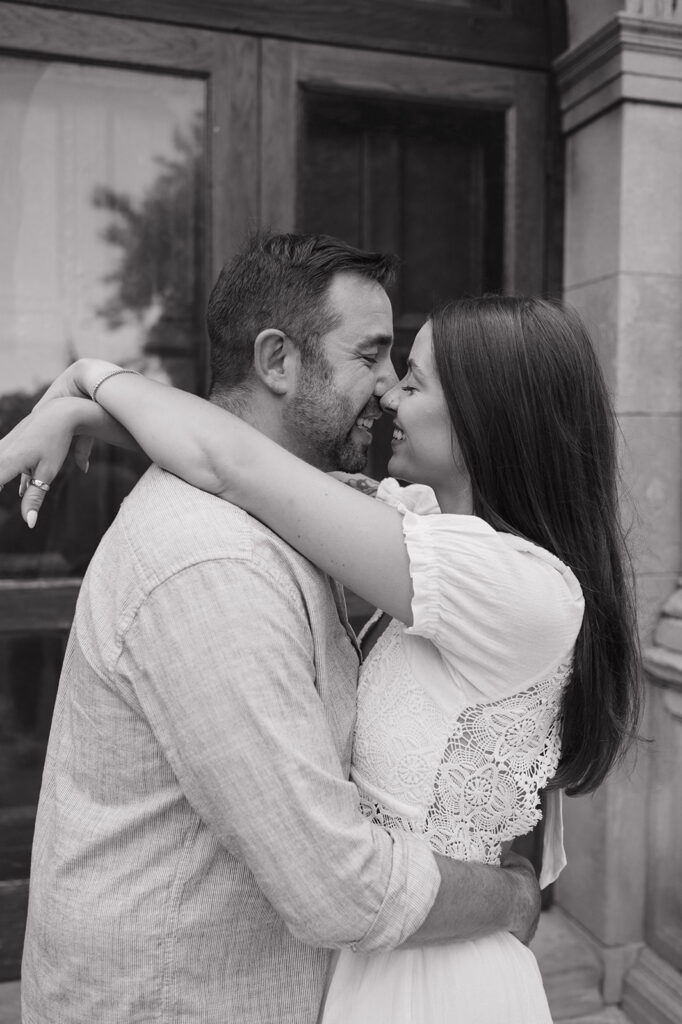 Black and white close up shot of a couple smiling and touching noses during their Grand Rapids engagement photos at Aquinas College.