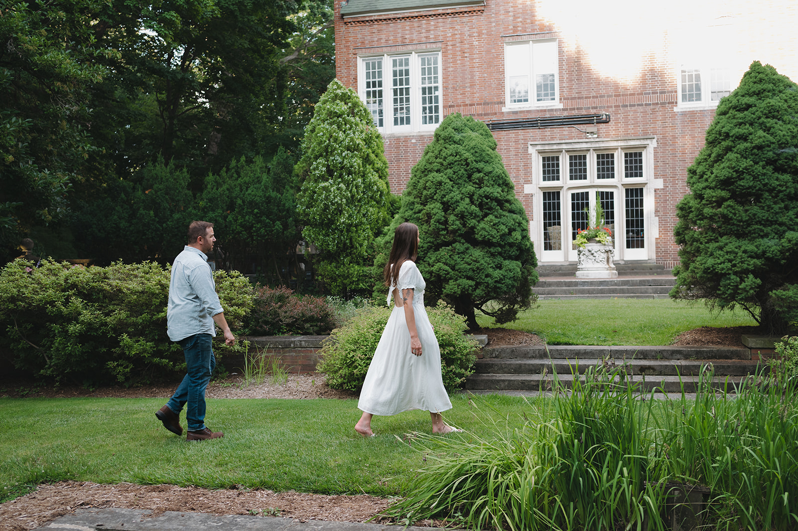 Couple walking across the lawn at Aquinas College.