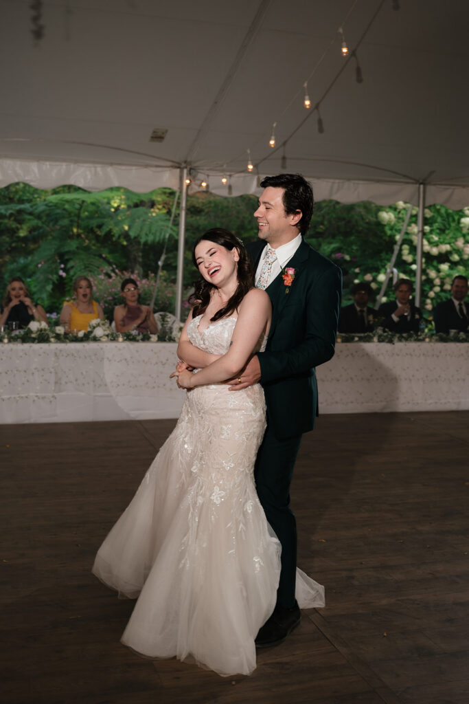 Bride and groom laughing during their first dance at an Everlastings in the Wildwood wedding.