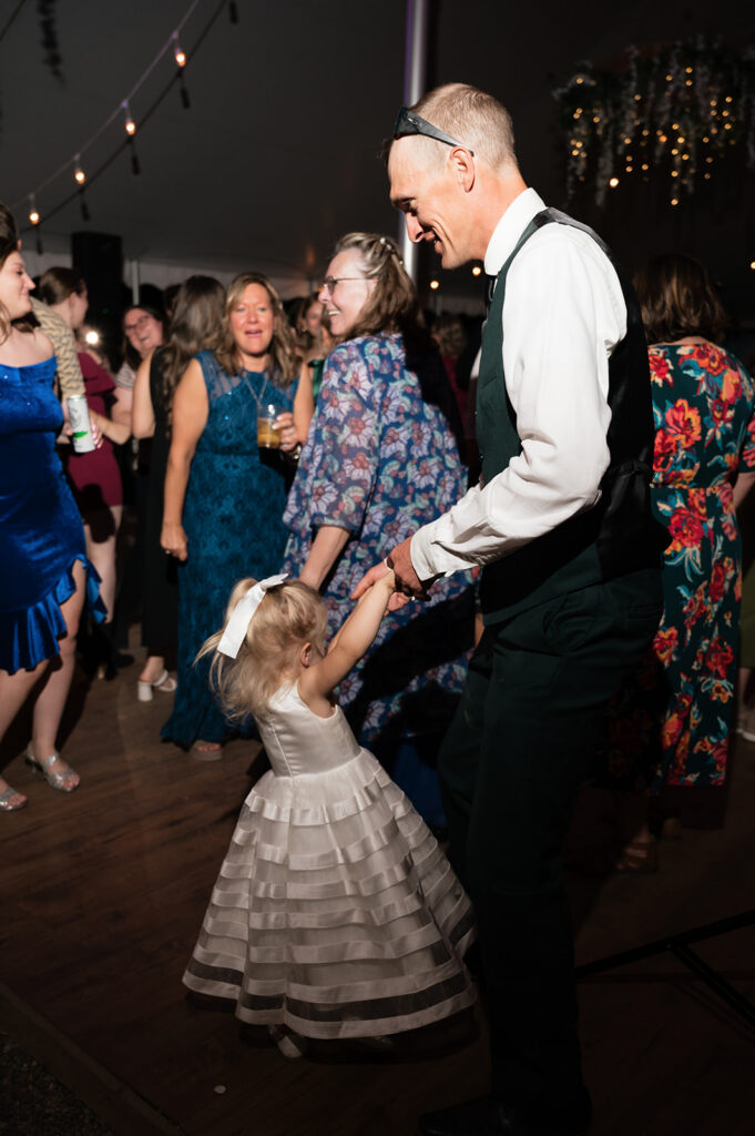 Guest dancing with young girl during the reception. 