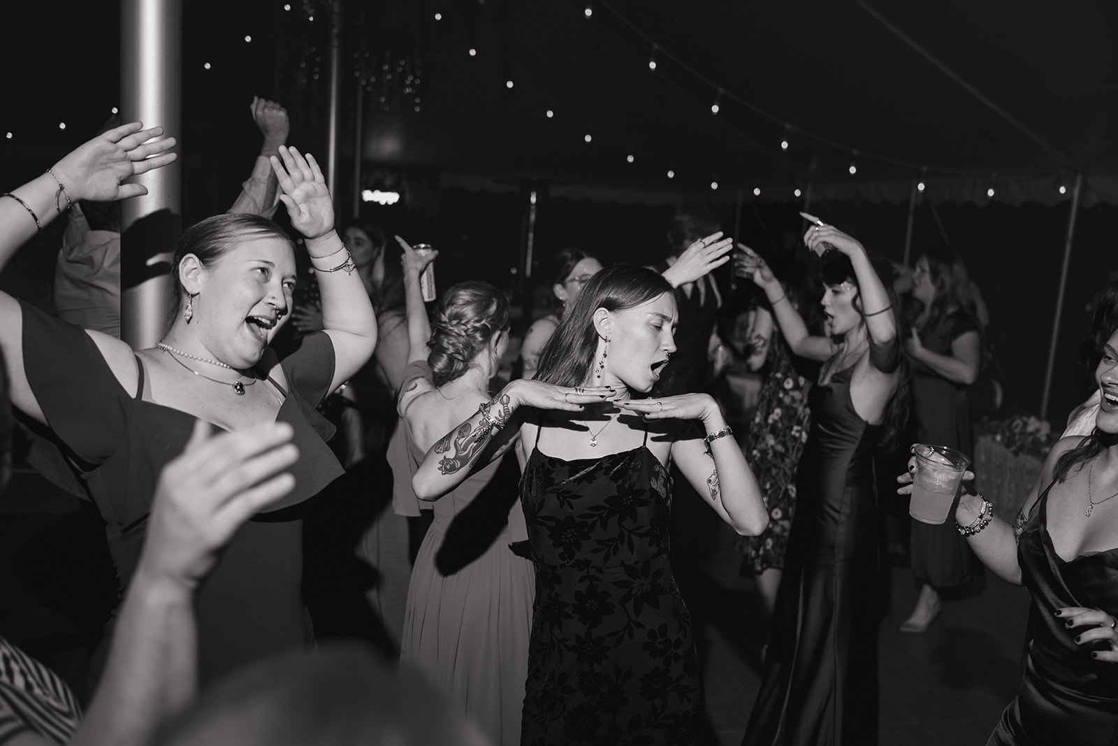 Black and white photo of guests dancing during the reception.