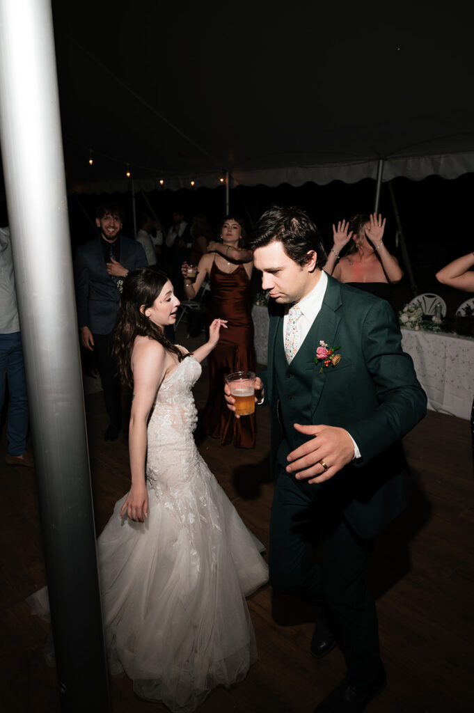 Bride and groom dancing together with guests during their Owosso, Michigan wedding reception.