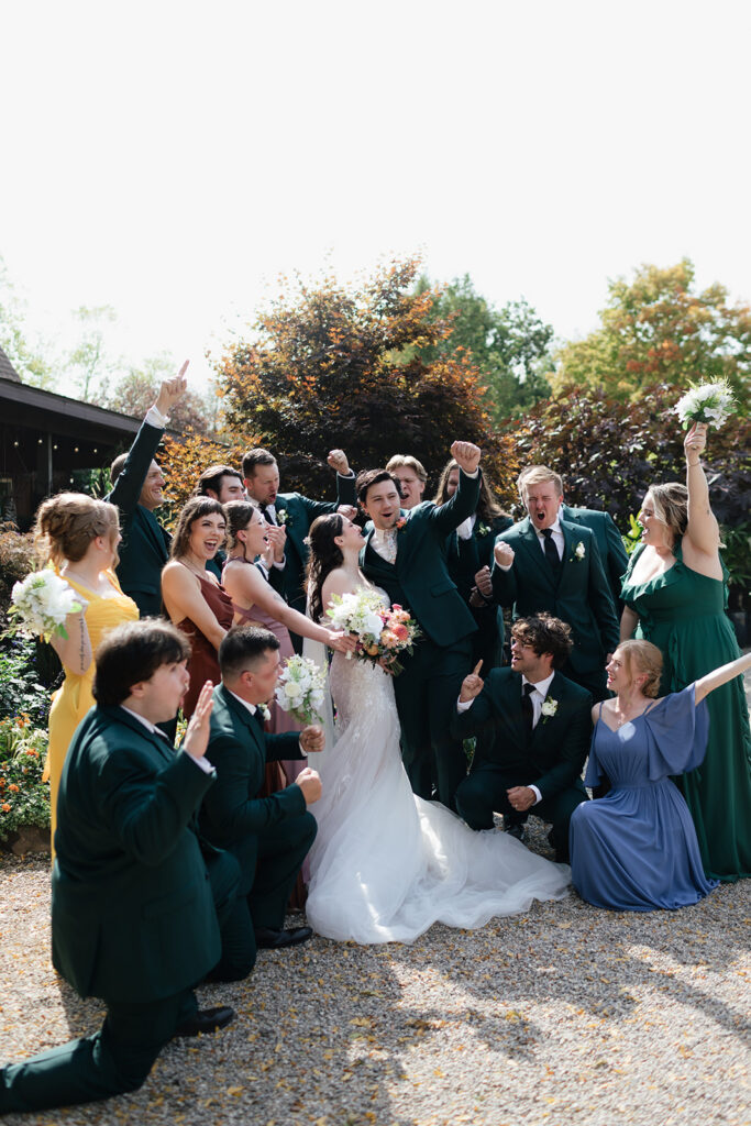 Bride and groom celebrating with their wedding party in the gardens at Everlastings in the Wildwood.
