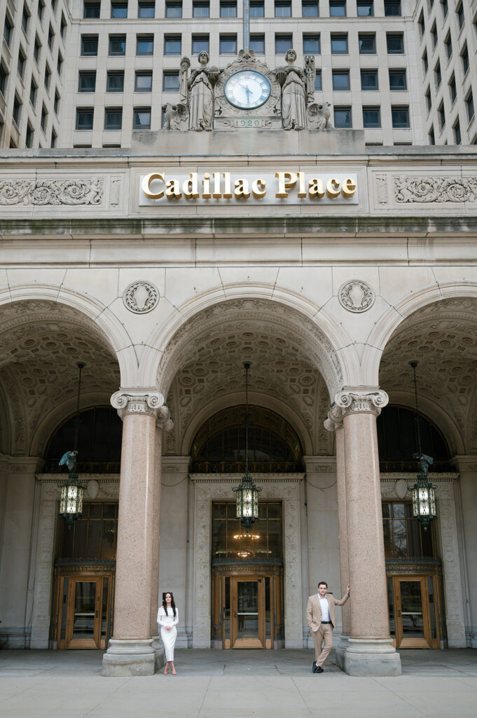 Couple posing outside of Cadillac Place for their Detroit engagement photos.