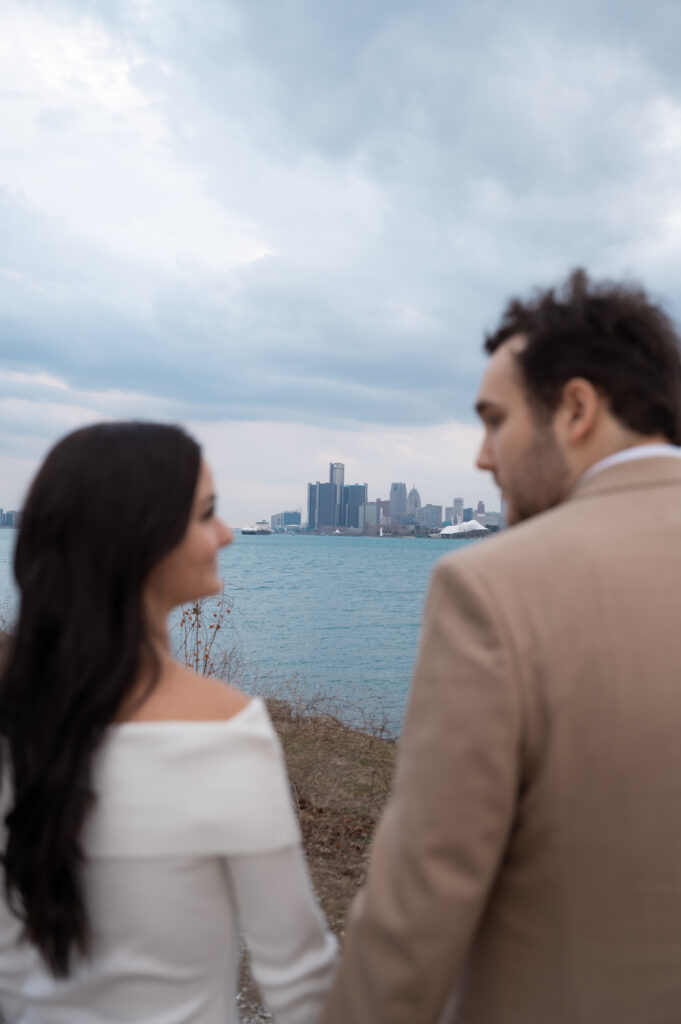 Couple admiring the Detroit skyline during their Detroit engagement photos.