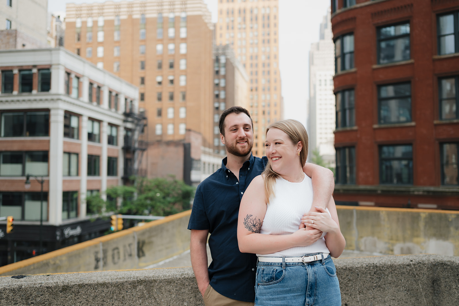 Couple posing for their Detroit engagement photos on a rooftop.