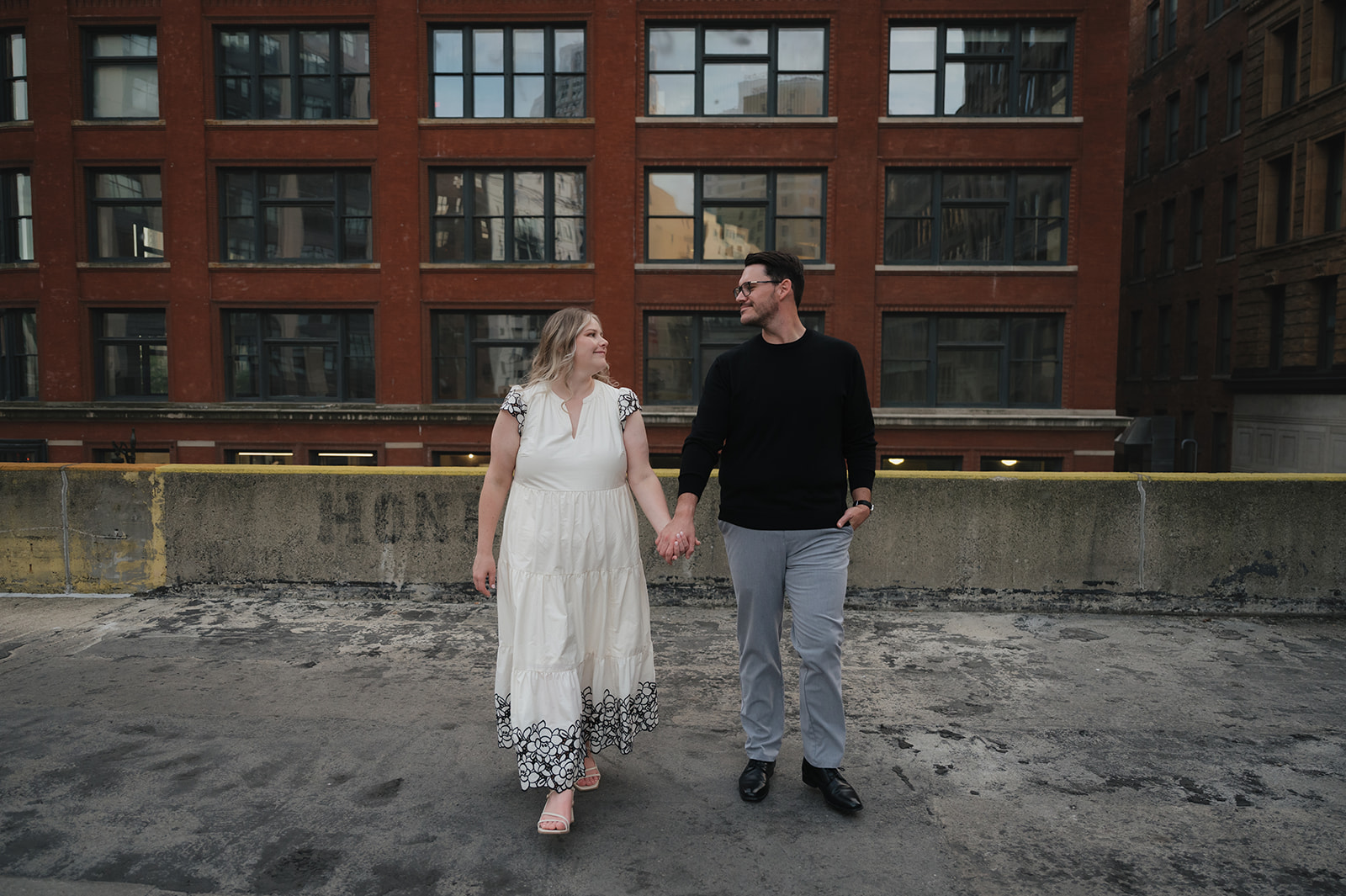 Couple holding hands on a rooftop.