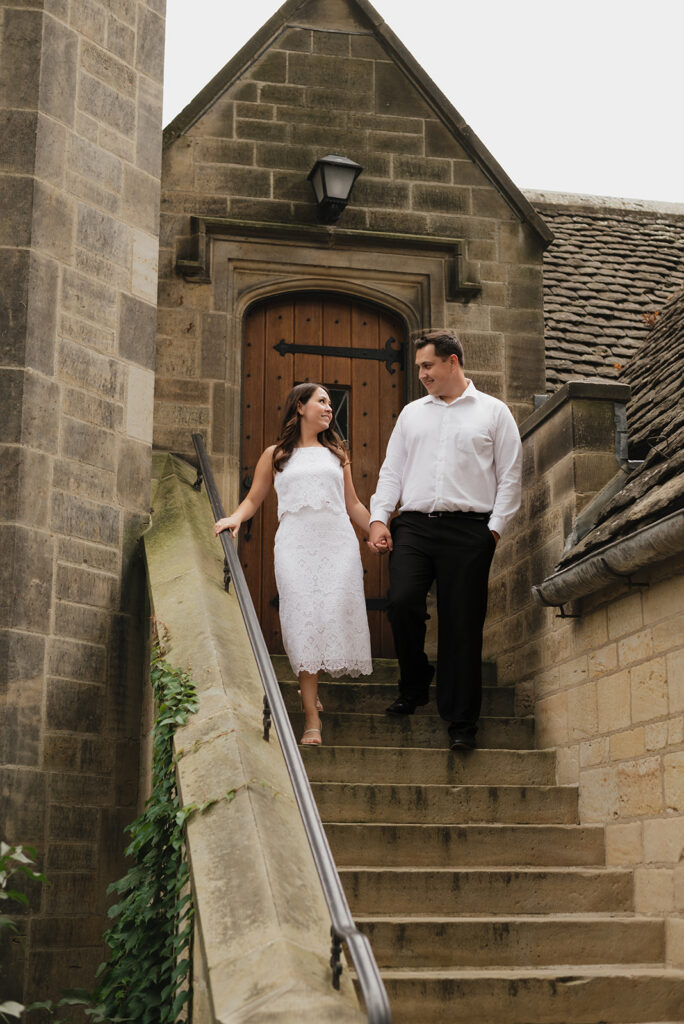 Couple walking down stairs for their Ford House engagement photos in Grosse Pointe Shores, Michigan.
