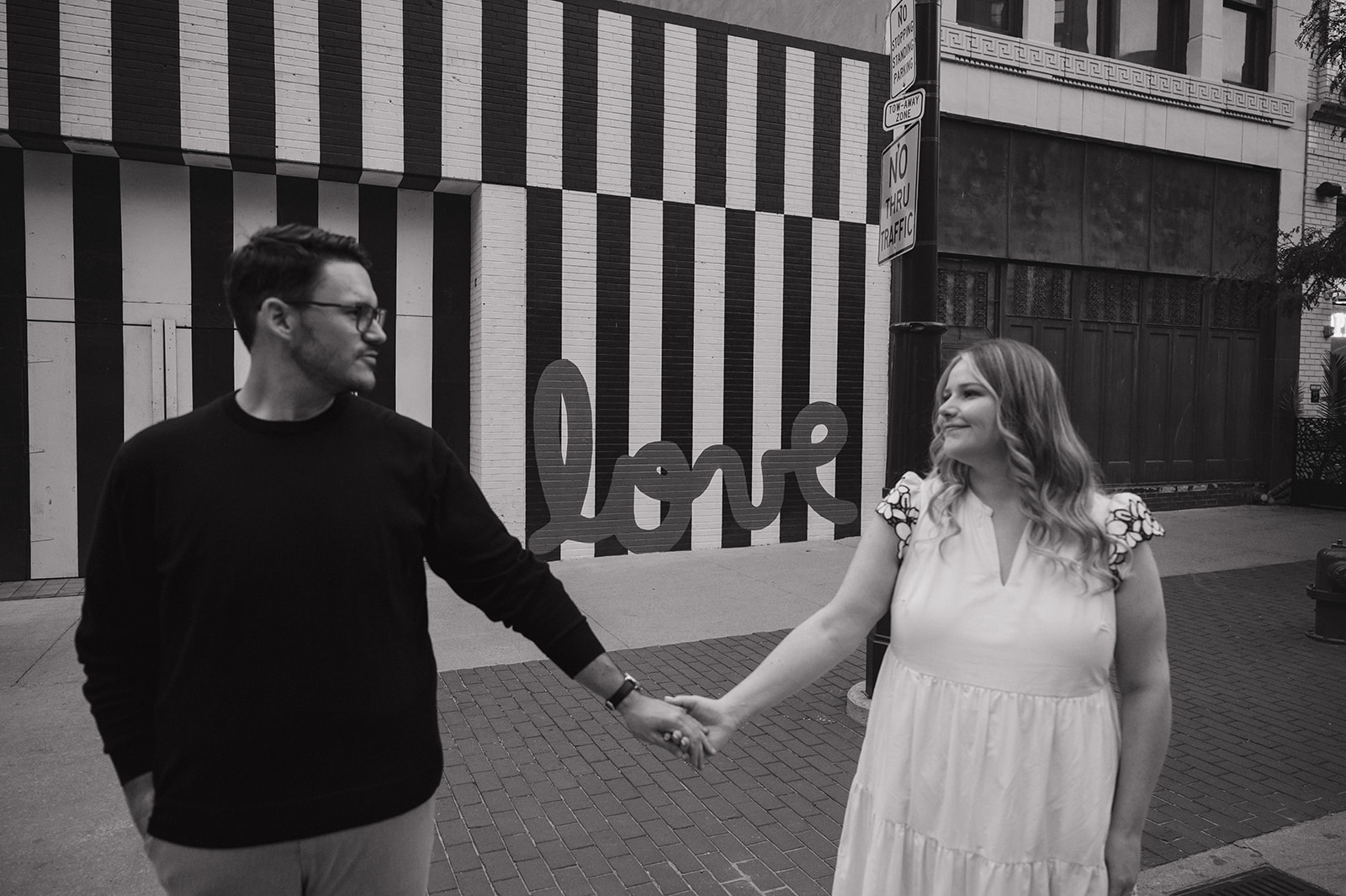 Couple walking in front of the Love Graffiti wall for their Detroit engagement photos.