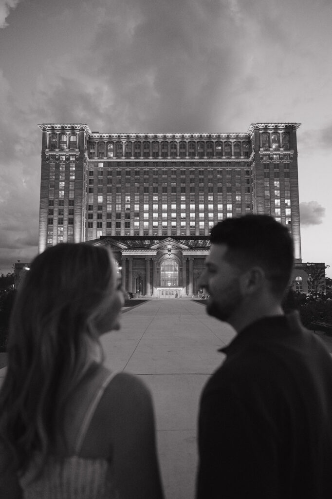 Couple posing outside of Michigan Central Station for their Detroit engagement photos.
