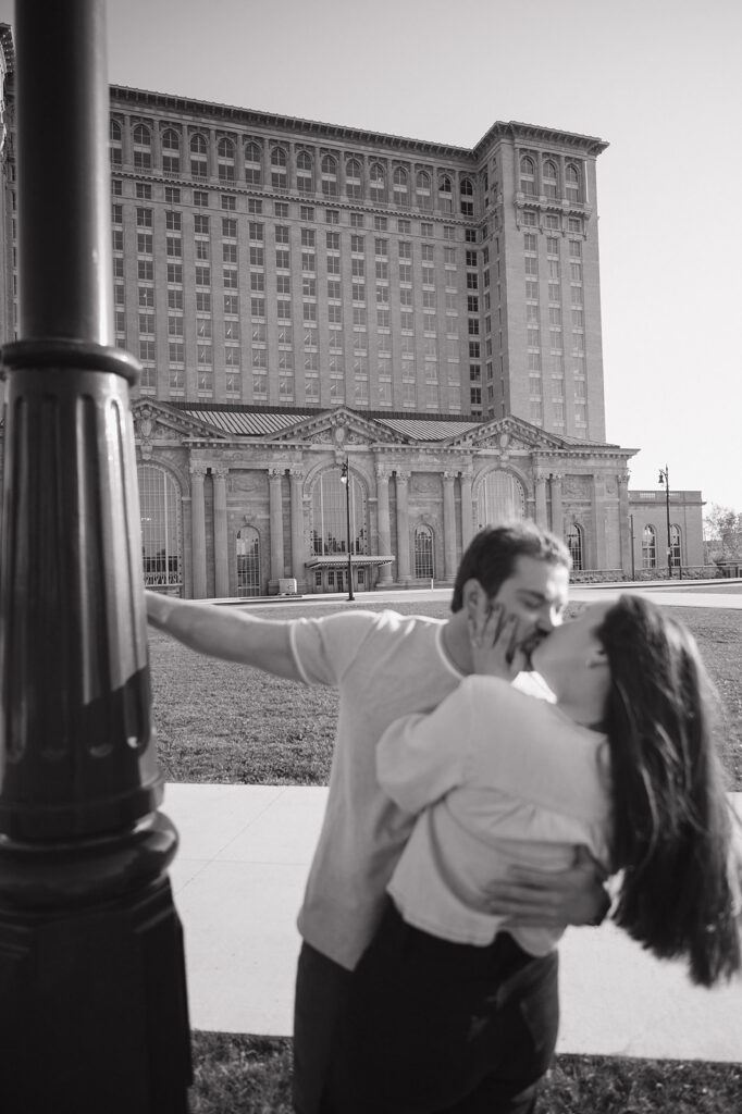 Couple kissing outside of Michigan Central Station for their Detroit engagement photos.