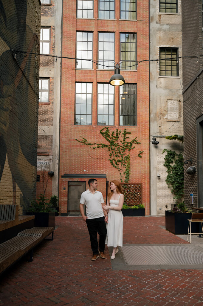 Couple posing in Parkers Alley for their Detroit engagement photos.