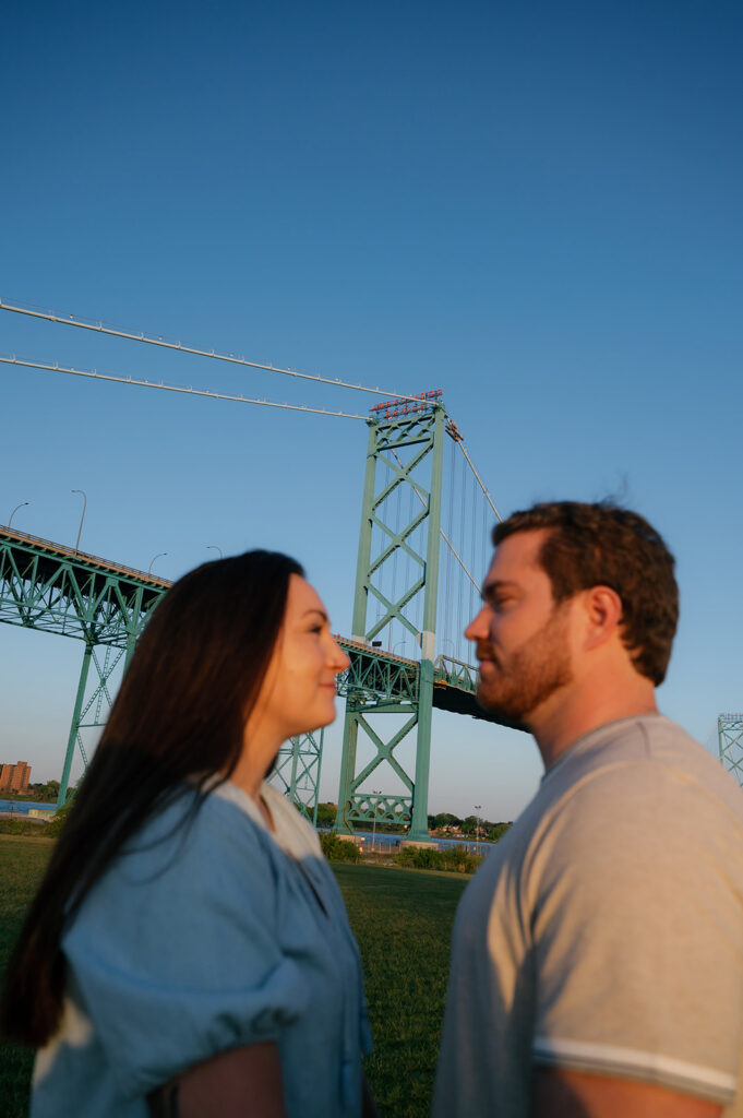 Couple posing with Ambassador Bridge in the background.