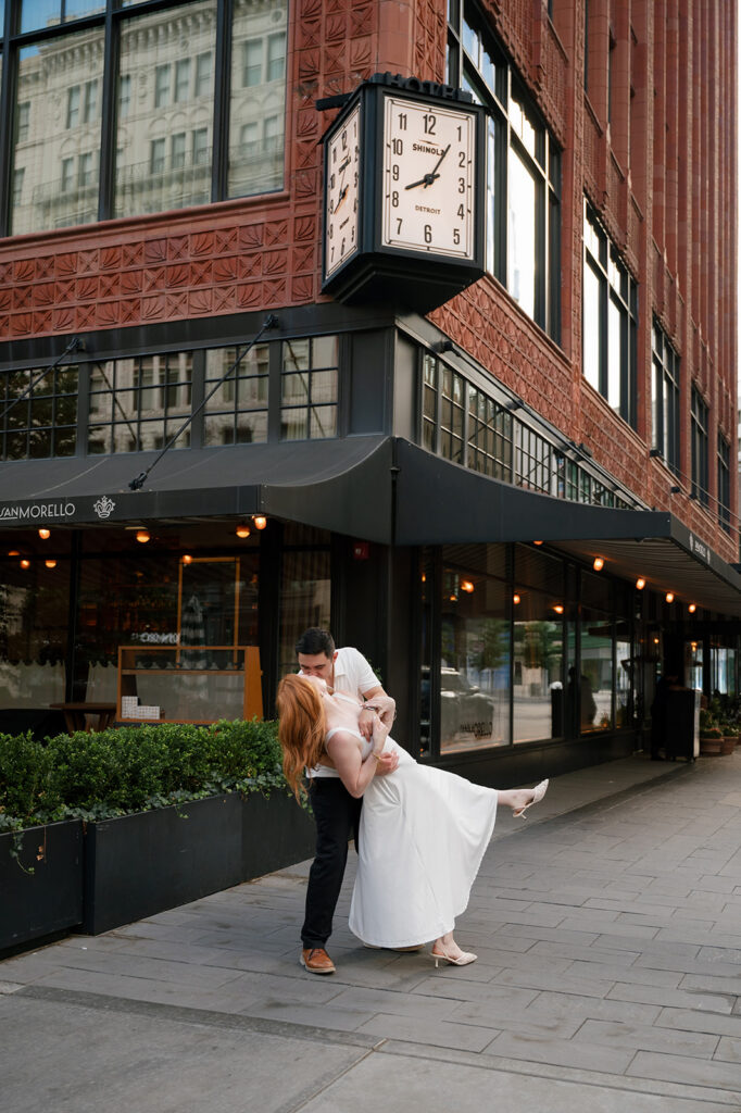 Couple kissing under the Shinola Hotel clock for their Detroit engagement photos.