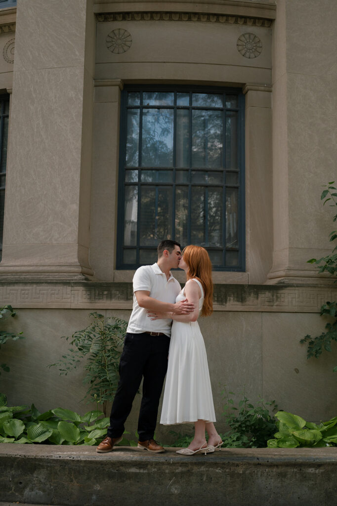 Couple kissing outside of Skillman Library for their Detroit engagement photos.